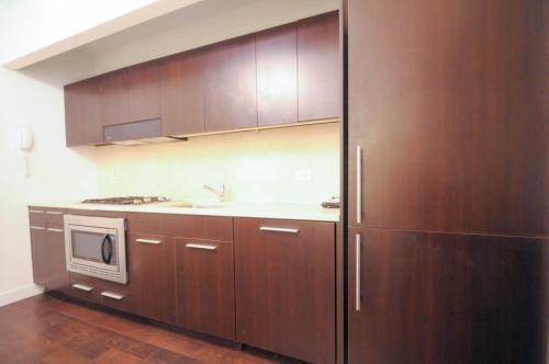 uma cozinha com armários de madeira e um micro-ondas em 2 BR in Wall Street em Nova York