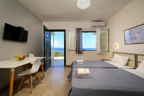 Habitación de hotel con 2 camas, mesa y escritorio en Nissaki Bay en Nisaki