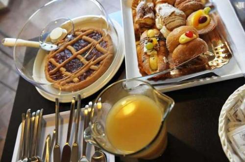 einem Tisch mit zwei Teller Essen und einem Glas Orangensaft in der Unterkunft Bed & Breakfast Viziottavo in Castiglion Fiorentino