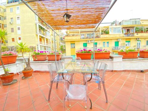 a table and chairs on a patio with plants at Attico Solimena - Private Terrace cityview in Naples