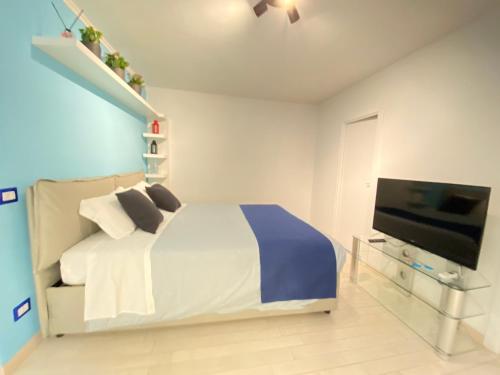 a bedroom with a bed and a flat screen tv at Attico Solimena - Private Terrace cityview in Naples