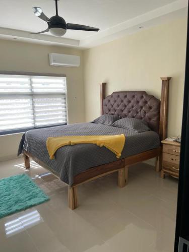 a bed in a bedroom with a ceiling fan at Catch a Vibes Bolt! - Ocho Rios in Ocho Rios