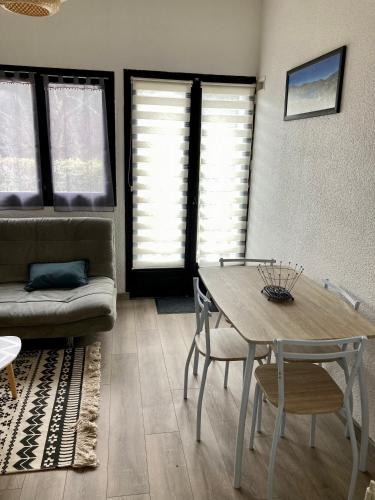 a living room with a table and a couch at Petite maison VILLEFORT in Villefort
