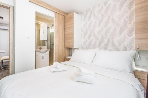 a bedroom with a large white bed with white pillows at Mini camping FUNTANA in Poreč