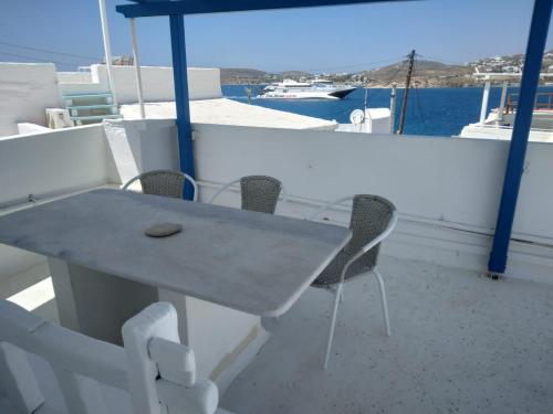 a table and chairs on a boat in the water at Octopus Suites Parikia in Parikia