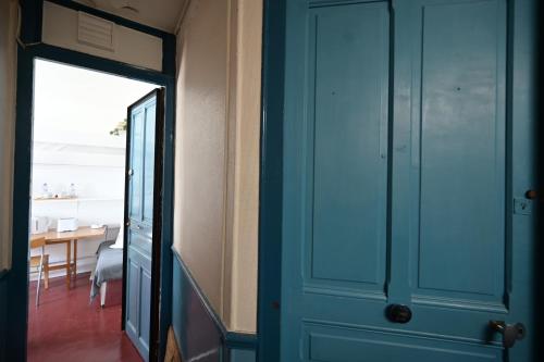 - une porte bleue dans une pièce avec salle à manger dans l'établissement Le studio d'Émilie, à Paris