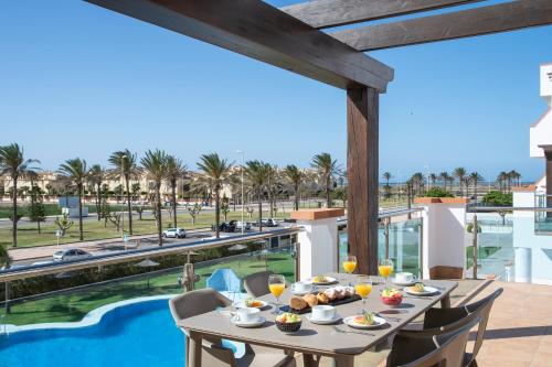 een eetkamer met een tafel en uitzicht op een zwembad bij Pierre & Vacances Almeria Roquetas de Mar in Roquetas de Mar