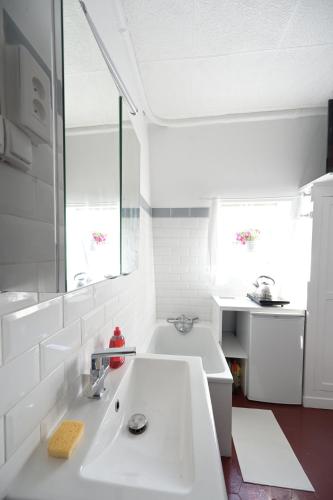 une cuisine blanche avec un évier et une fenêtre dans l'établissement Le studio d'Émilie, à Paris