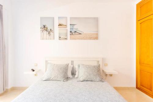 1 dormitorio con 1 cama con 2 cuadros en la pared en Amplio y cómodo apartamento en Callao Salvaje., en Callao Salvaje