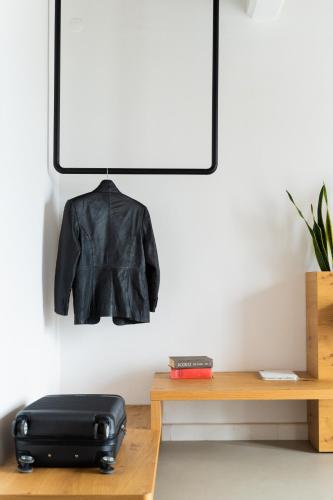 a black jacket hanging on a wall next to a table at Rhenia Hotel in Tourlos