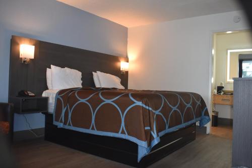 a bedroom with a bed with a brown comforter at Super 8 by Wyndham Riverside AL in Riverside