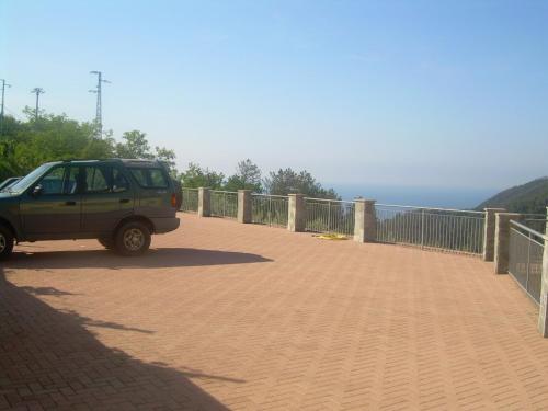 a green car parked on a bridge near the ocean at Ariabuona in Moneglia