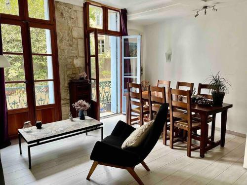 un salon avec une table et une chaise dans l'établissement La charmante maison aux volets bleu - Montpellier, à Montpellier
