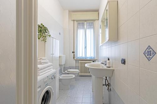 a white bathroom with a sink and a toilet at Clelia Apartments in Parma