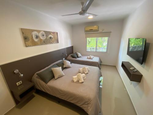 Habitación pequeña con 2 camas y TV. en Cálido y Amplio Dpto Céntrico 1D en Formosa