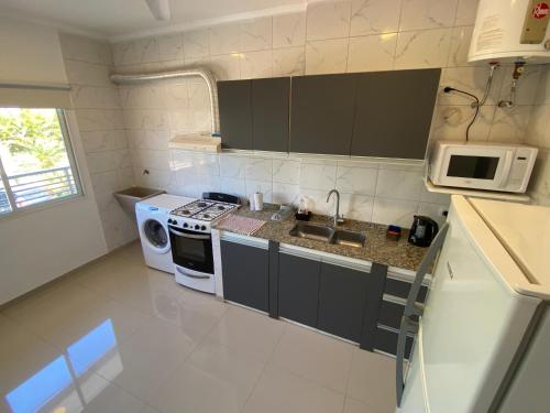 a small kitchen with a stove and a microwave at Cálido y Amplio Dpto Céntrico 1D in Formosa