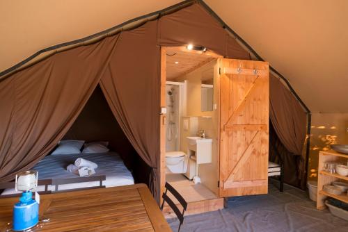 sypialnia z łóżkiem w namiocie w obiekcie Huttopia De Meinweg w mieście Herkenbosch
