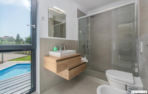 a bathroom with a sink and a toilet and a swimming pool at Caeli in Petehi