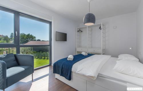 a bedroom with a bed and a chair and a window at Caeli in Petehi