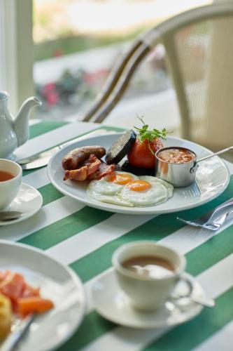 a table topped with plates of food and cups of coffee at The Old Government House Hotel & Spa in St Peter Port