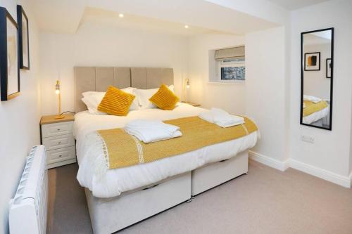 a bedroom with a large bed with yellow pillows at Central Ripon apartment - view of the Cathedral! in Ripon