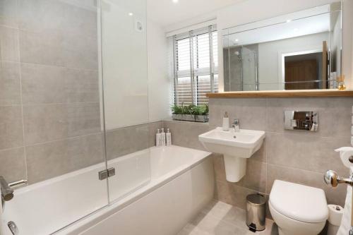 a bathroom with a tub and a sink and a toilet at Central Ripon apartment - view of the Cathedral! in Ripon