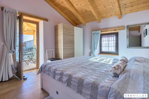 a bedroom with a large bed and a balcony at Ive in Orbanići