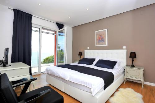 a bedroom with a bed and a desk and a window at Karmen Adriatica in Kukljica