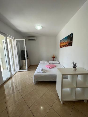 Un dormitorio con una cama y una mesa. en Apartments Karma en Novalja