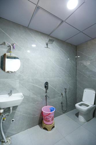 a bathroom with a sink and a toilet and a mirror at HOTEL GREEN VILLA in Surat