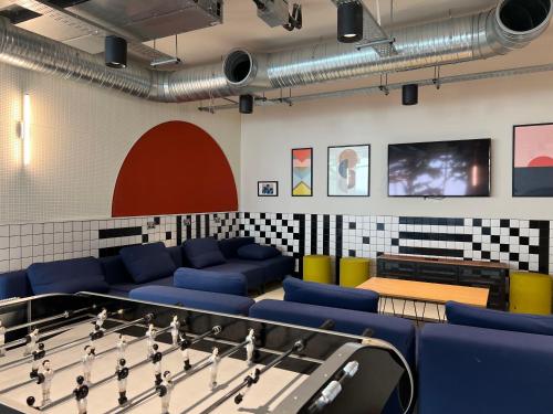a ping pong room with blue couches and a table at ALTIDO Affordable Dublin Parkgate - Adults only in Dublin