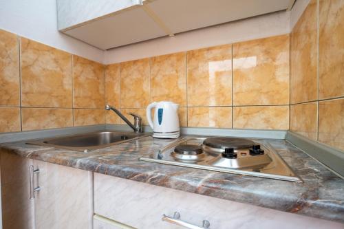 a kitchen with a sink and a stove at Studio APARTMANI LEŽENIĆ in Neum