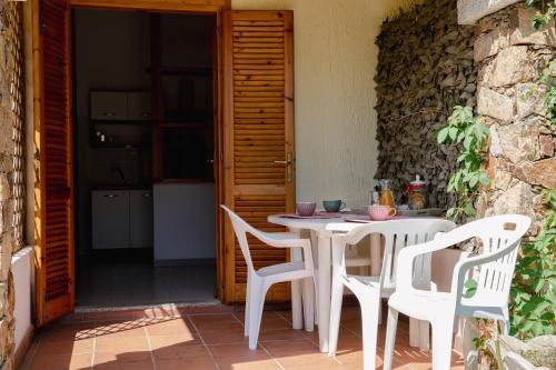 een witte tafel en stoelen op een patio bij Il Vecchio Pozzo in Porto Ottiolu