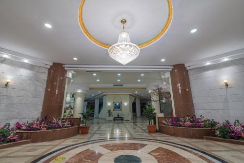a large lobby with a large chandelier and flowers at Dexon Roma Hotel in Hurghada