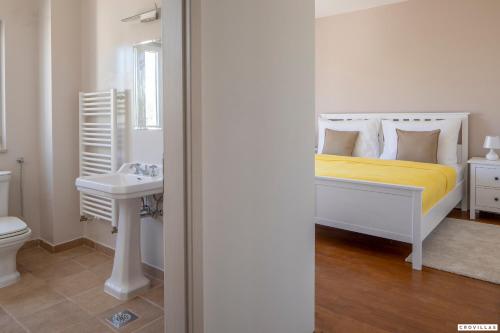 ein weißes Schlafzimmer mit einem Bett und einem Waschbecken in der Unterkunft Milla Hvar in Rudina