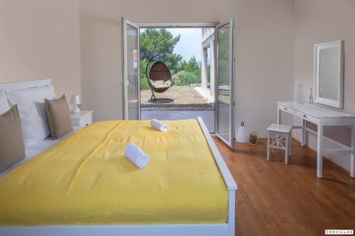 a large yellow bed in a room with a desk at Milla Hvar in Rudina
