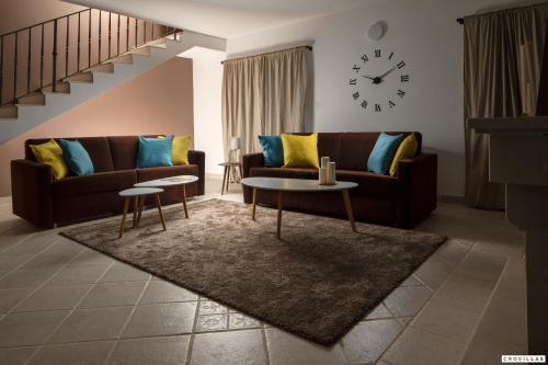 a living room with a couch and a clock on the wall at Milla Hvar in Rudina