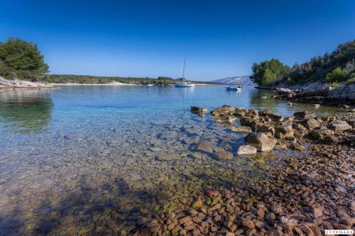 a large body of water with rocks in the water at Milla Hvar in Rudina