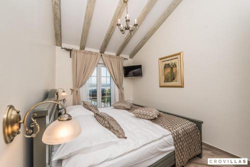 een slaapkamer met een bed met witte lakens en een raam bij Mek in Pridraga