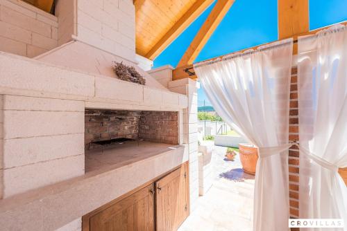 een patio met een stenen open haard in een huis bij Mek in Pridraga