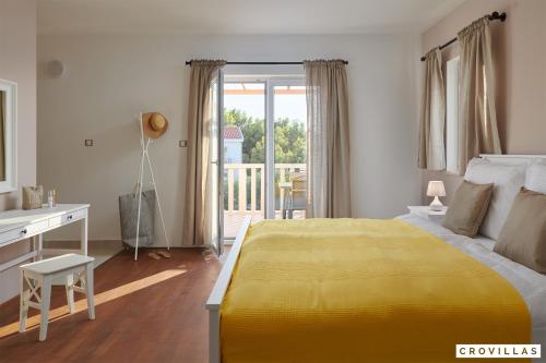 a bedroom with a yellow bed and a desk and a balcony at Nella Hvar in Rudina