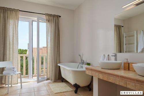 a bathroom with a tub and a large window at Nella Hvar in Rudina