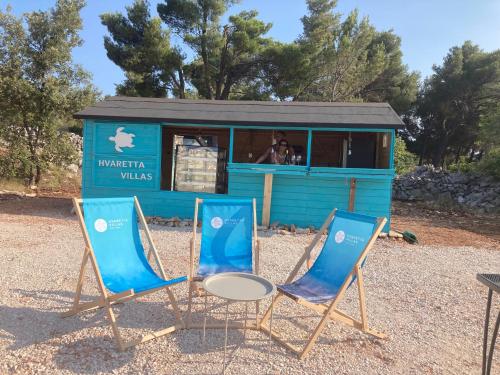 two chairs and a table in front of a building at Nella Hvar in Rudina