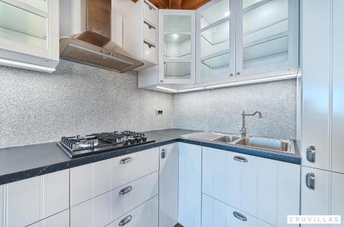 a kitchen with white cabinets and a sink at Lux I in Murter