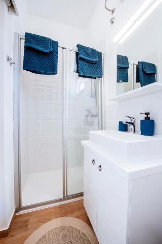 a white bathroom with a shower and a sink at Muntan in Kraj