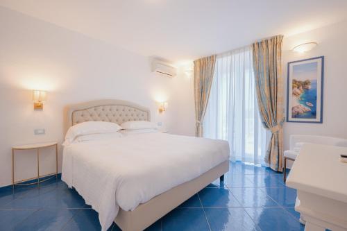 a bedroom with a large white bed and a window at Grand Hotel Le Rocce in Gaeta