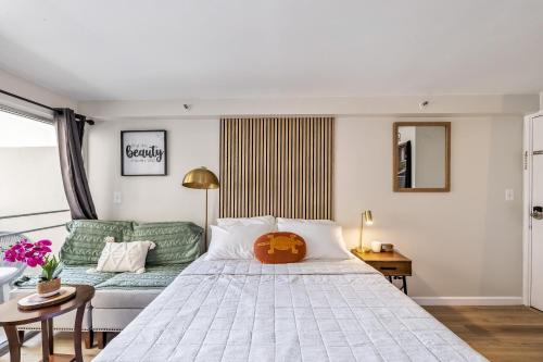 um quarto com uma cama grande e um sofá em Bright & Cozy Condo Unit with Balcony! em Honolulu