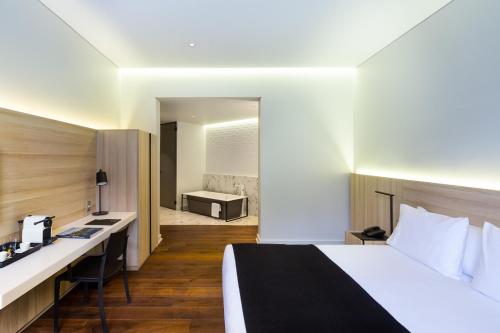 a hotel room with a bed and a desk at Hotel Altiplanico Bellas Artes in Santiago
