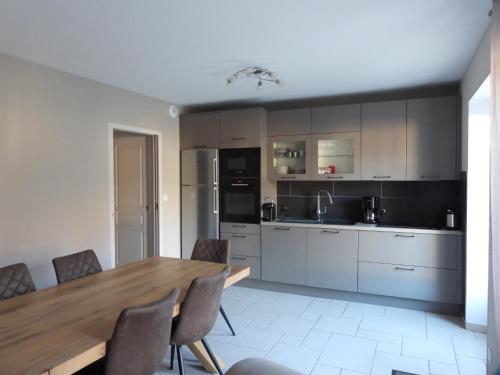 a kitchen with a wooden table and a dining room at La Maison de Vinciane in Maligny