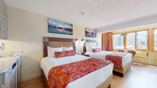 a hotel room with two beds and a sink at Surfside On The Lake in Lake George
